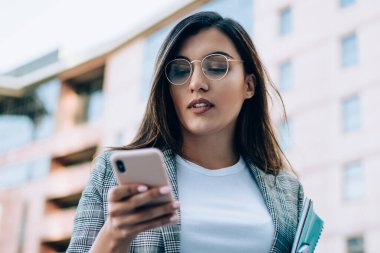 Resmi giyinmiş Türk bayan yönetici, güncelleme ayarları için akıllı telefon uyarısını kontrol ediyor, gözlüklü çekici kadın mobil uygulama ile çevrimiçi mesaj gönderiyor 4G 'ye bağlı