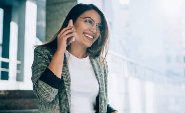 Şen şakrak Türk kadını, şehir ortamında boş zamanlarında akıllı telefon cihazıyla uluslararası sohbetten keyif alıyor.