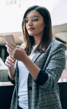 İnternet sitesinden ziyaretçilerin online istatistiklerini izleyen çekici Türk kadın blogcu, akıllı telefon ayarlarını güncellemek için başvuru formlarını kontrol eden modaya uygun gözlüklü bin yıllık kadın