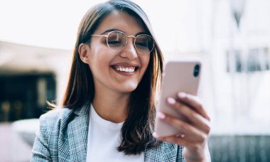 Geleceğin komedi fragmanını izlerken gülümseyen mutlu kadın film sitesi için 4G kablosuz bağlantısını kuruyor, neşeli genç blogcu takipçileriyle grup sohbetinde mesajlar alıyor