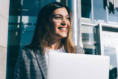 Uzaktan kumanda sırasında gülümseyen gözlüklü, vizyon düzeltme gözlüklü yetenekli kadın serbest yazar, olumlu Türk metin yazarı