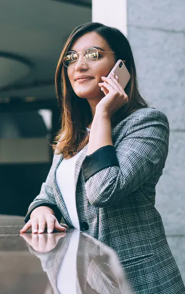 Moda bir ceket giymiş çekici kadın girişimcinin portresi meslektaşımla uluslararası sohbet yapmak için gezinen iyi internet bağlantısının keyfini çıkarıyor, online iletişim kavramı