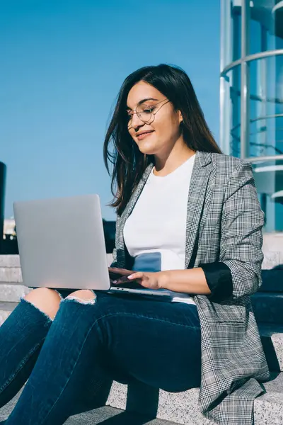 İnternet sitesindeki bir sonraki yazı için dizüstü bilgisayar uygulaması ve şehir ortamında açık kablosuz ağ kullanan çekici kadın metin yazarı, netbook 'ta online sohbetten hoşlanan pozitif hipster kız