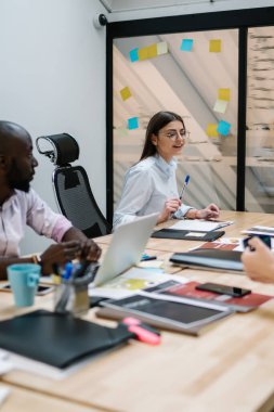 Şirketin konferans odasında beyin fırtınası sürecinde birlikte çalışan çok kültürlü erkek ve kadın finans uzmanları, ofiste toplantı sırasında finansal profesyoneller tarafından planlanan strateji