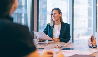 İşbirliği için ofiste yapılan beyin fırtınası sırasında masaüstünde oturan başarılı profesyonel meslektaşlar, şirkette çalışan pozitif erkek ve kadın girişimciler fikirler hakkında konuşuyorlar.