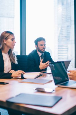 Konferans odasında yapılan beyin fırtınası sırasında şirketin finansal stratejisi konusunda işbirliği yapan zeki profesyonel insanlar, masaüstü ve danışmanlık alanında birlikte oturan ciddi ortaklar.