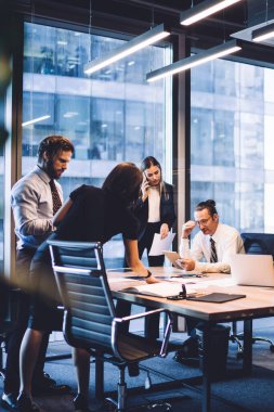 Profesyonel erkek ve kadın iş arkadaşlarının işbirliği süreci, resmi takım elbiseli iş kadını takım çalışması sırasında partnerlerin dokunmatik bloknotlarından gelen e-postaları okurken akıllı telefon aygıtı ile operatörle iletişim kuruyor