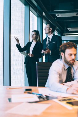 Yetişkin erkek ve kadın iş arkadaşları çalışma odasında takım oluşturuyorlar. Bir grup başarılı iş adamı ofis içi iletişimlerinde birbirleriyle işbirliği yapıyorlar.