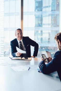 Resmi giyinmiş erkek ve bayan meslektaşlar, ofiste beyin fırtınası sırasında iş birliğinin çalışma planını tartışıyorlar. Modern dizüstü bilgisayarı takım çalışması için kullanan yaratıcı mutlu ortaklar.