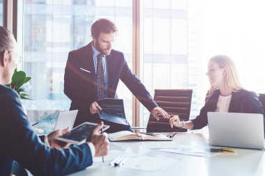 Profesyonel finans uzmanları ofis içi işbirliği sırasında rapor detaylarını tartışıyor, olgun erkek ve kadın şirket yöneticileri masaüstü yakınlarındaki bilgilerde birlikte beyin fırtınası yapıyorlar