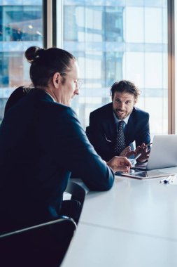 Şirket ofisindeki başarılı iş arkadaşlarıyla işbirliği yaparken resmi olarak kameraya gülümseyen neşeli erkek patronun portresi. İçeride beyin fırtınası yapan mutlu deneyimli uzmanlar.