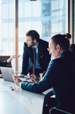 Ofis masaüstü, erkek ve kadın profesyonel danışmanlık, beyin fırtınası toplantılarında arama üretken stratejisi üzerine işbirliği sırasında belgelerle ilgili sorunları çözen bir grup iş adamı