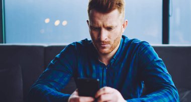 Konsantre hipster adam cep telefonu üzerinden online ödeme yapma şaşkın, ciddi adam modern akıllı telefon gadget menüsünde veri bilgilerini kontrol, teknoloji ve iletişim kavramı