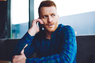 Sakallı kafkas adam 4g internet bağlantısı kullanarak iş süresi hakkında patron danışmanlığı ile ciddi akıllı telefon görüşmesi yapıyor, iyi görünümlü hipster adam cep telefonu üzerinden operatöre çağrı