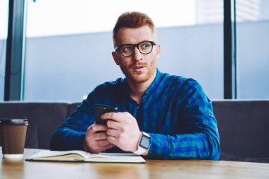 Kahve dükkanında öğrenme sırasında internet bağlantısı tartışmak için müşteri hizmetleri çağrı beklerken gözlük düşünceli hipster adam düşünme, adam kapalı öğrenme