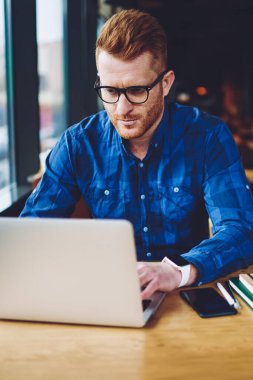 Yeni dizüstü bilgisayar cihazı, modern teknoloji ve iletişim kavramı ile kahve dükkanında uzaktan çalışırken web sitesinde makale için ilginç içerik oluşturma ciddi kafkas erkek metin yazarı