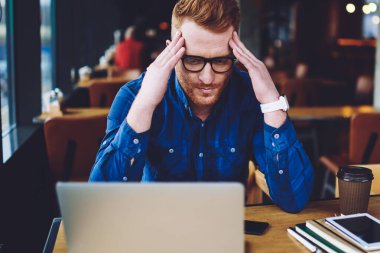 Hayal kırıklığına kafkas erkek serbest çalışma coworking alanında son tarihten itibaren mutsuz duygu işten kötü haber ile e-posta aldı, şaşkın adam antivirüs uygulaması ile sorunu çözmek için fikirler hakkında düşünme