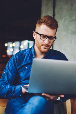 Ciddi işadamı dizüstü bilgisayar cihazı üzerinde ücretsiz wifi bağlantısı kullanarak ortakları ile organizasyon toplantı olay için bilgi arıyor, antivirüs uygulaması hakkında yoğunlaştırılmış serbest okuma haberleri