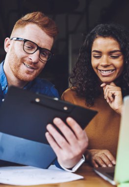 Pozitif başarılı çeşitlilik serbest meslektaşları modern dizüstü bilgisayarlar ile masaüstünde otururken birlikte çalışma alanında işbirliği sırasında başlangıç projesi için organizasyon planı analiz