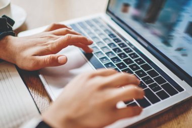 Modern dizüstü bilgisayarın klavyesinde ders metni yazmak için yazı yazan kadınların kırpılmış görünümü. Web sitelerinde arama bilgileri ve netbook aygıtında kablosuz internet kullanarak uygulama kurulumu