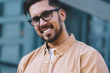 30 yaşındaki mutlu bir adamın yarım boy portresi dijital teknolojiyi kullanmaktan kaçarken kameraya bakıyor, Kafkas erkek blogcu modern cep telefonuyla iyi internet bağlantısı kuruyor.