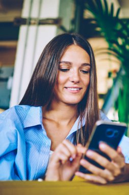 Mutlu erkek ve kadın akıllı telefon cihazları tutuyor ve canlı iletişimi görmezden gelen arkadaşlarıyla mesajlaşıyor, kadın ve erkek boş zamanlarında sosyal ağlardaki profilleri güncellemek için dijital cihazlar kullanıyor.