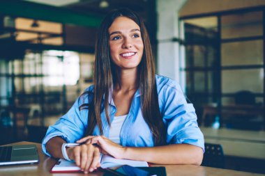 Genç neşeli hippi kız dizüstü bilgisayarında oturuyor ve üniversite ödevlerine hazırlanırken gözlerini kaçırıyor. Netbook 'lu başarılı bir kadın içeride planlama yaparken gülümsüyor.