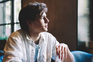 Düşünceli genç hippi kız arkadaşıyla boş zamanlarında kafeterya masasının önünde otururken düşünceli genç adam dizüstü bilgisayar için kablosuz internet bağlantısı üzerine kafa yoruyor.