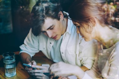 Milenyum Kafkasyalı erkek ve kadın cep telefonlarında internet bağlantısı, teknoloji ve nesil hakkında danışmanlık için sağlayıcı şirketten online müşteri hizmetleri ile iletişim kurar.