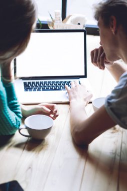 Romantik çiftin seyahat sayfasında internet üzerinden rezervasyon yapmak için iyi oteller hakkında bilgi araması, modern netbook 'ta blog yazmak için yetenekli erkek ve kadın kurma uygulaması