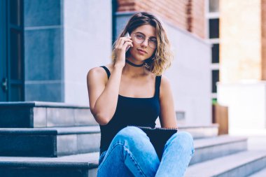 Üniversite programı hakkında danışmanlık için uluslararası telefon görüşmesi yapan çekici kız öğrencinin portresi ve klasöre not düşmesi, genç bir kadının şehir ortamında kameraya bakması