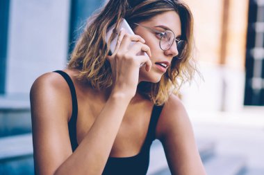 Cep telefonu hesap dengesi ile sorun tartışmak için operatör ile konuşurken moda güneş gözlüğü güzel Kafkas hipster kız, iletişim için gezici bağlantı kullanarak çekici kadın