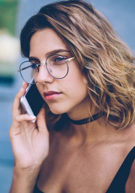 Ciddi hipster kızı danışmanlık için operatöre arıyor. Gezgin, güneş gözlüklü çekici bir genç kızla iletişim kurmak için cep telefonuyla mobil bir konuşma yapıyor.