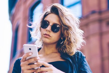 Cep telefonu üzerinde 4g kablosuz internet kullanarak Turizm hakkında içerik makalesi ile güven seyahat Blogger Yayıncılık yayın, telefon uygulama yükleme güneş gözlüğü çekici hipster kız