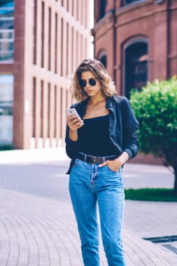 Kendine güvenen gezgin kadın otelin rezervasyonunu yapmak için internet araştırması yapıyor. Beyaz tenli hippi kız, şehirde yürürken akıllı telefon cihazıyla arkadaşına mesaj yazıyor.