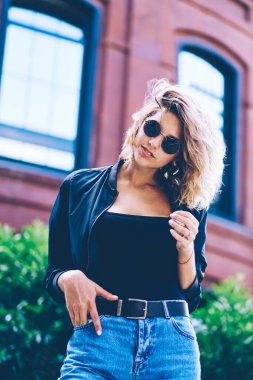 Tatil açık havada genç çekici hipster kız harcama zaman yarı uzunlukta portre, eğlence üzerinde şehir alanı keşfetmek ederken kamera bakarak moda güneş gözlüğü olumlu güzel kadın