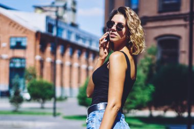 Çekici hippi kızın yarım boy portresi şehir merkezinde yürüyor ve boş zamanlarında uluslararası akıllı telefon konuşmaları yapıyor, genç trend bir kadın kiralık araba için taksi servisini arıyor.