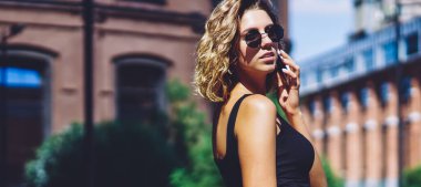 Çekici hippi kızın yarım boy portresi şehir merkezinde yürüyor ve boş zamanlarında uluslararası akıllı telefon konuşmaları yapıyor, genç trend bir kadın kiralık araba için taksi servisini arıyor.