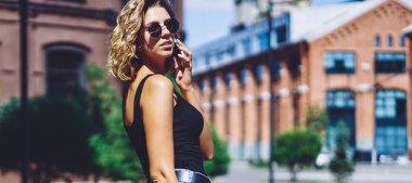 Çekici hippi kızın yarım boy portresi şehir merkezinde yürüyor ve boş zamanlarında uluslararası akıllı telefon konuşmaları yapıyor, genç trend bir kadın kiralık araba için taksi servisini arıyor.