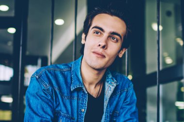 Rahat kıyafet giymiş hipster adam elinde optik gözlük tutan ve düşünceli serbest zaman sırasında uzağa bakarak, dalgın erkek öğrenci arkadaş beklerken üniversite sınavları hakkında düşünme