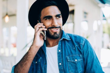 Şık giyinmiş mutlu hippi çocuk uygulamayla olumlu akıllı telefon konuşmasının keyfini çıkarıyor. Boş zamanlarında uluslararası telefon görüşmesi yapan neşeli İspanyol adam gezintiye çıkıyor.