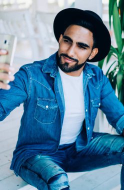 Milenyum yakışıklısı elinde kafein içeceği ve selfie fotoğraflarıyla paket servis bardağı tutan adam, Türk erkek blogcu moda sayfasında içerik yayını yarattığı için kendisini fotoğraflıyor