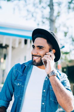 Şık giyinmiş İspanyol hippi şehir ortamında pozitif hücre sohbetinin keyfini çıkarıyor. Neşeli adam telefon numarasını soruyor. Cevap alınca mutlu olan kim?