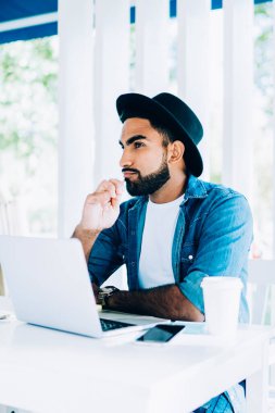 Düşünceli erkek serbest çalışan, verileri ve medya dosyalarını korumak için modern laptop aygıtı için daha iyi bir antivirüs programı üzerinde kafa yoruyor.