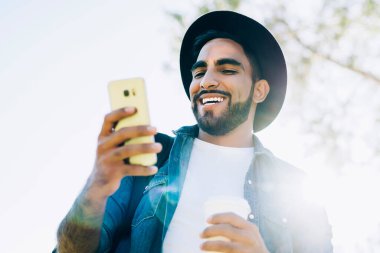 Şık giyinen mutlu erkek turistin manzarasının altında, binlerce yıllık blog yazarlarının web sitesinde olumlu adam haberleri okuduğu boş zamanlarında şehir bölgesini keşfetmek için çevrimiçi seyahat rehberiyle birlikte gelen e-postalarla heyecanlanmıştı.