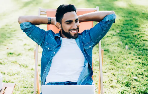 Günlük kotlar giymiş neşeli bir adam etrafı kolaçan ediyor ve öğrenme sürecinde sınav hazırlıkları için hayatın ve zamanın tadını çıkarıyor. Dizüstü bilgisayarı olan başarılı bir Türk bacağının üzerinde dinleniyor.