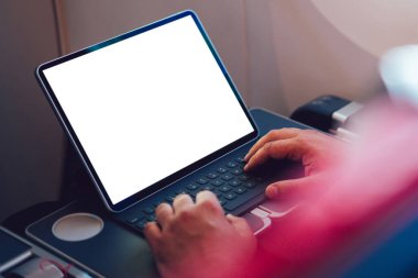 Uçaktaki kablosuz internete dokunmatik ped ile bağlanan genç bir uçuş yolcusu uçak kabin penceresinin yanında oturuyor. Ağ şablonu için boş ekranı, serbest çalışma için dijital göçebe işini düzenle