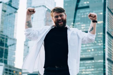 Yeni megalopolis 'i keşfettiği için uluslararası seyahati kutlayan neşeli erkek turistin tam boy portresi. Elleri havada başarılı bir Kafkas gezgini.