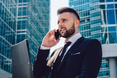 Elinde kağıt klasörü olan kafası karışmış bir erkek muhasebeci rapordan bilgileri kontrol ediyor ve şehir merkezindeki uluslararası bağlantıyı kullanarak yapılan hataları tartışmak için finansal uzmanlara başvuruyor.