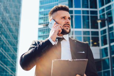 Megalopolis caddesinde muhasebe sırasında cep telefonu cihazını online danışmanlık için kullanan kafası karışmış erkek ekonomistin altında akıllı bir adam uygulamayla uluslararası cep telefonu sohbeti yapıyor.